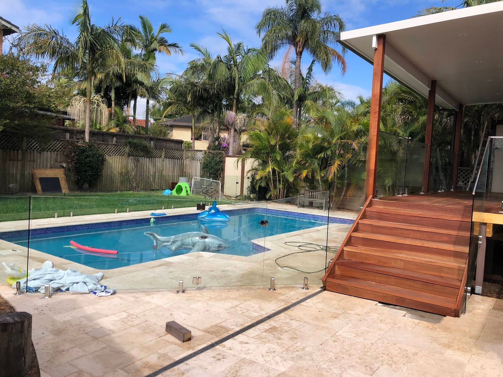 Backyard Swimming Pool With a Wooden Deck — ClearView Glass Pool Fencing In Sutherland Shire, NSW