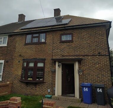 A brick house with solar panels on the roof.