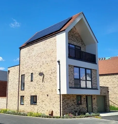 Two men are installing solar panels on the roof of a building.