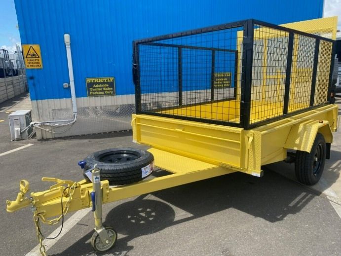 A Yellow Trailer is Parked in Front of a Blue Building — Voyager Trailers in Yarrawonga, NT