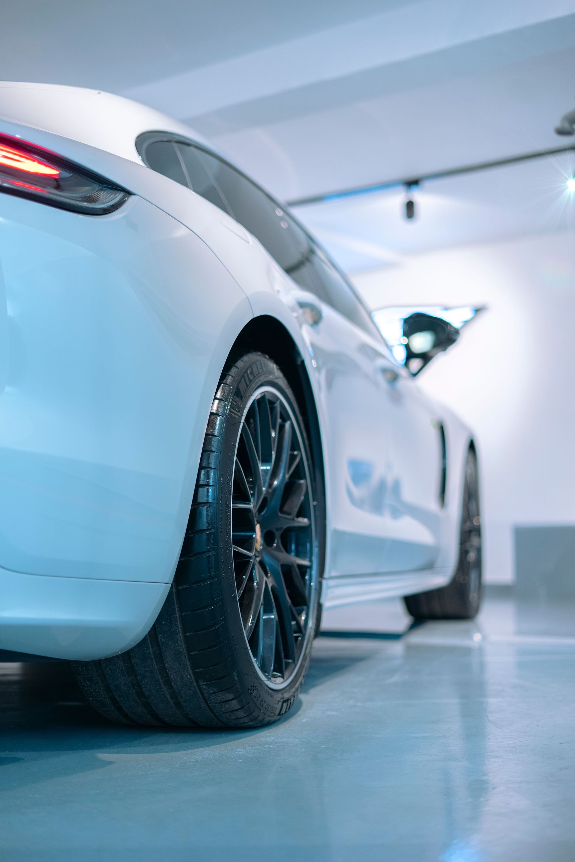 White Tesla parked in a two-car garage with a gray epoxy floor coating