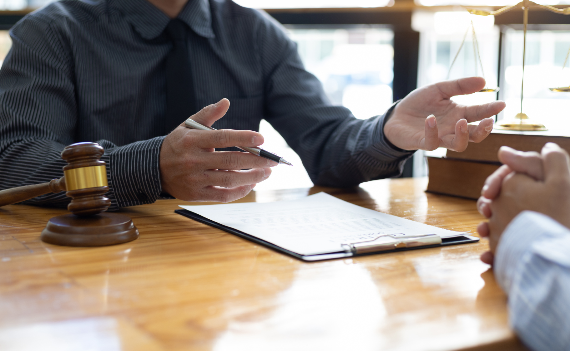 A judge is sitting at a table talking to a client.