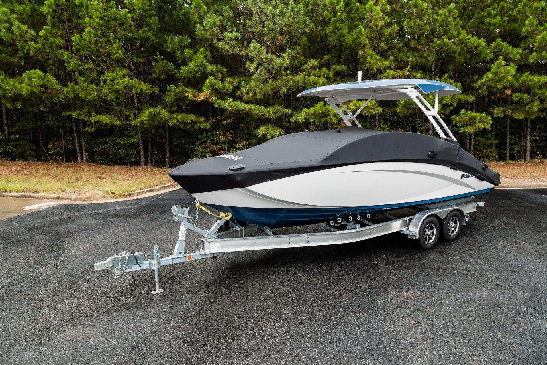 A boat is parked on a trailer in a parking lot.