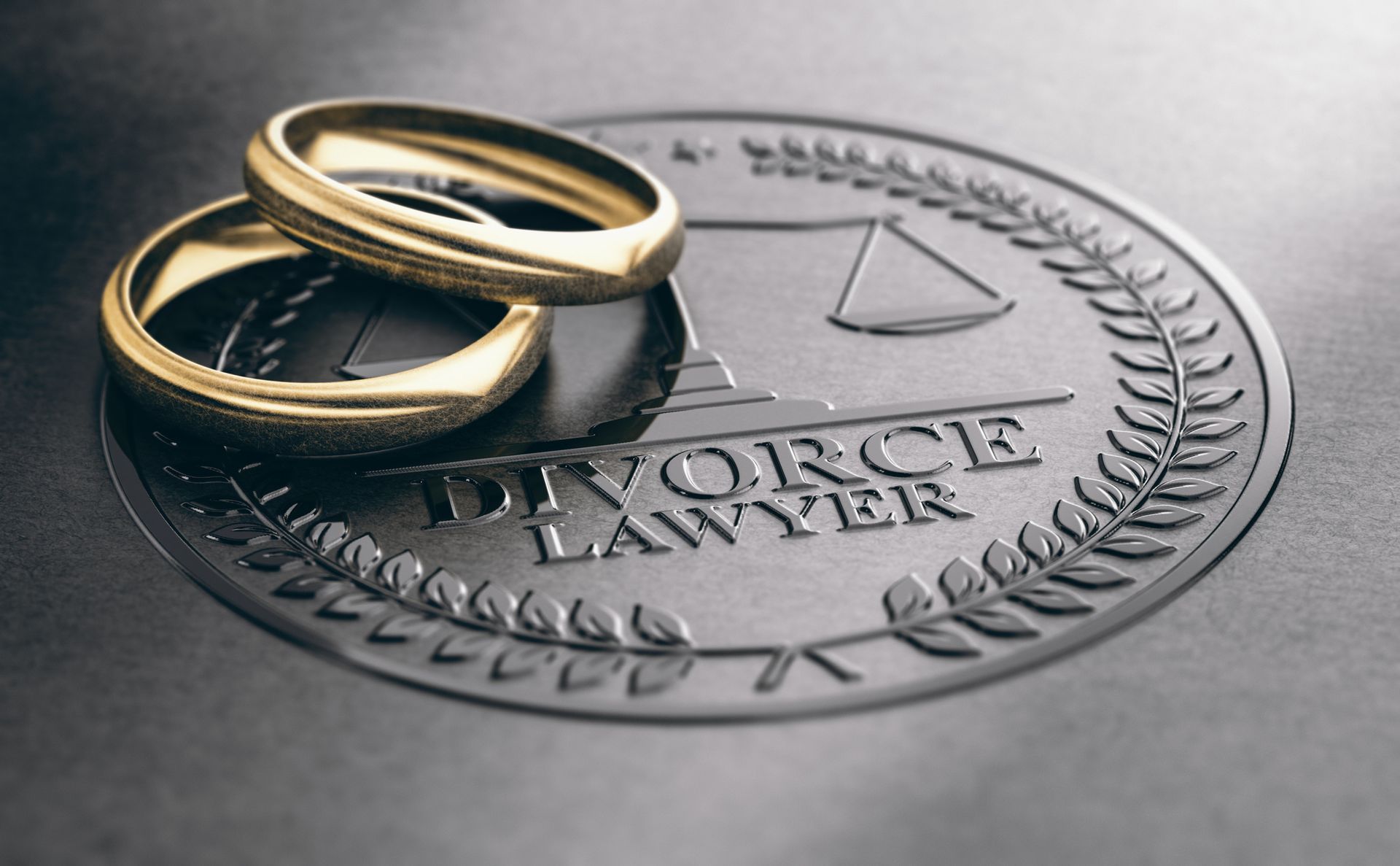Two gold wedding rings placed on a document labeled Divorce Lawyer.