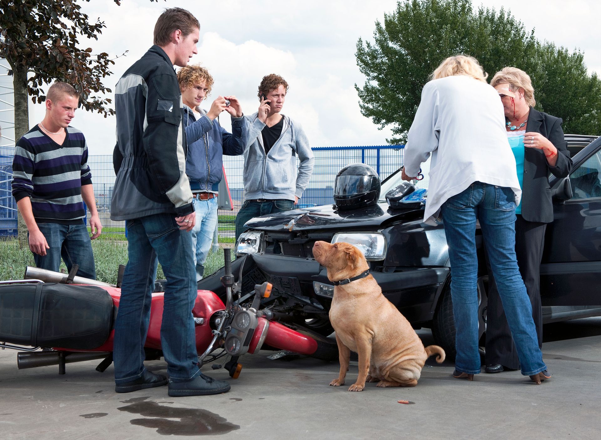 A group of people gathers around a motorcycle and a dog in Hasting, Nebraska.