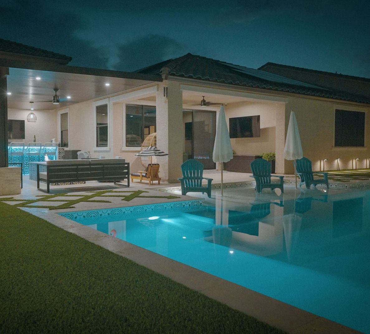 There is a large swimming pool in the backyard of a house.
