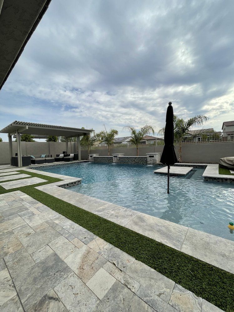 A large swimming pool with a black umbrella in the middle of it.