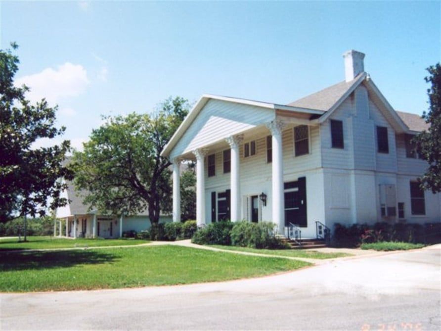 A large white house with columns and black shutters