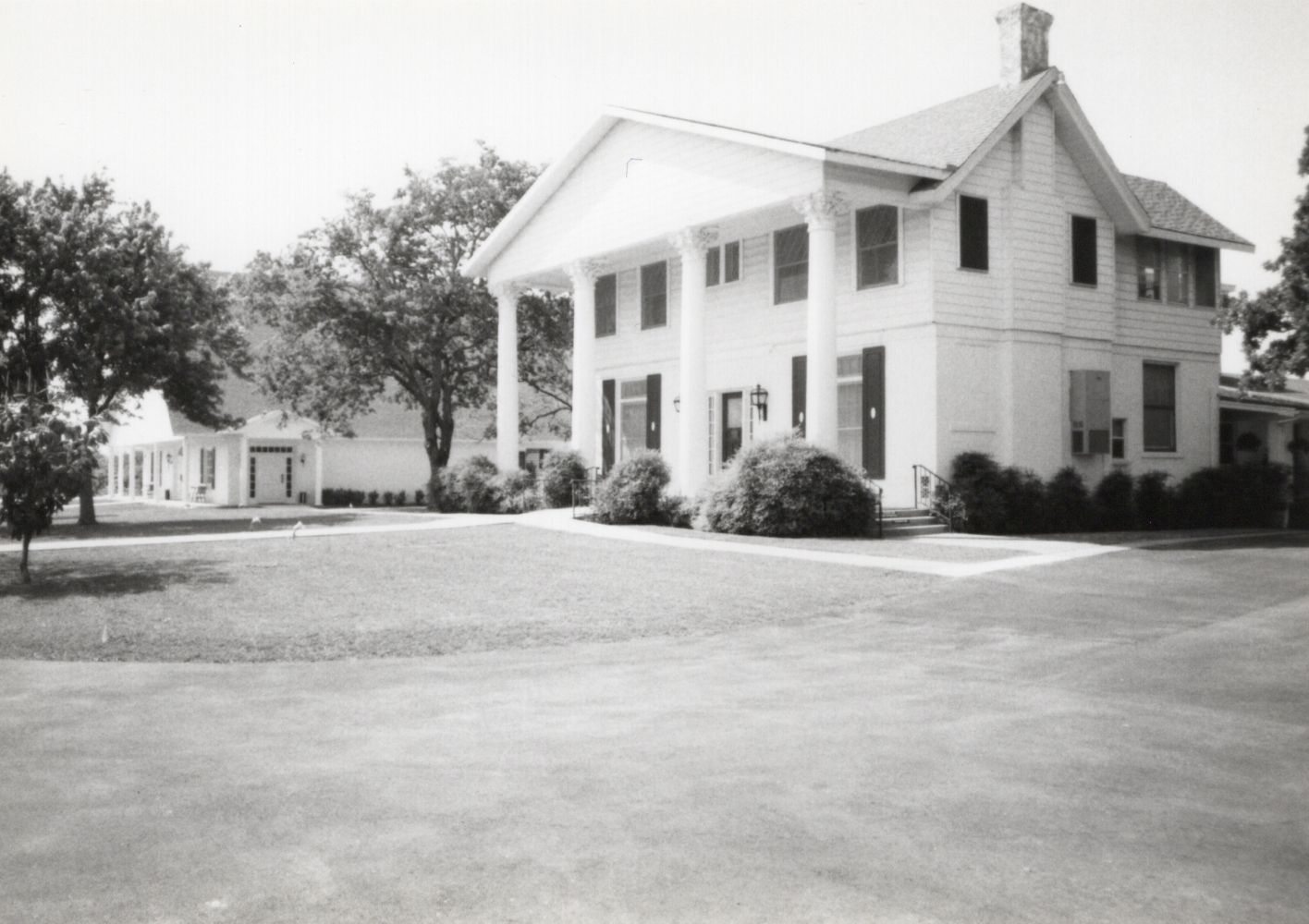 A group of people are posing for a picture in front of a house.