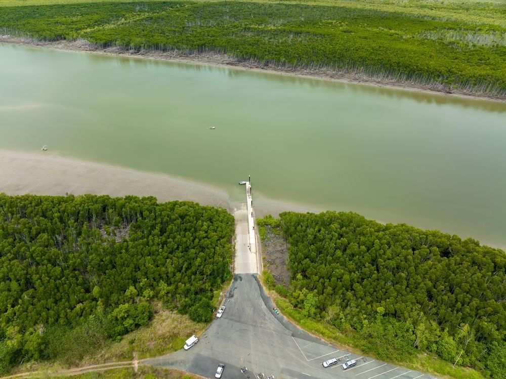 An Aerial View Of A Road Leading To A Body Of Water Surrounded By Trees — SF Produce In Proserpine, QLD