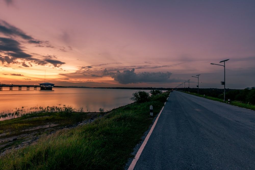 A Road Leading To A Bridge Over A Body Of Water At Sunset — SF Produce In Nebo, QLD