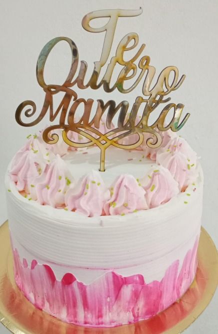 Pastel con glaseado rosa y blanco, cubierto con un adorno para pastel