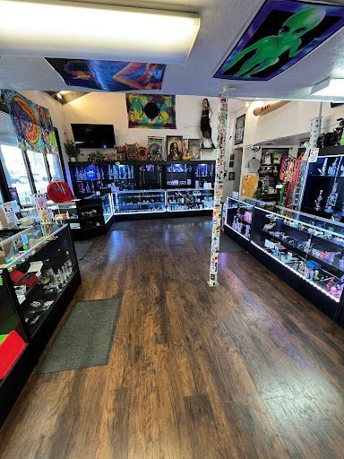 The inside of a store with wooden floors and lots of shelves.