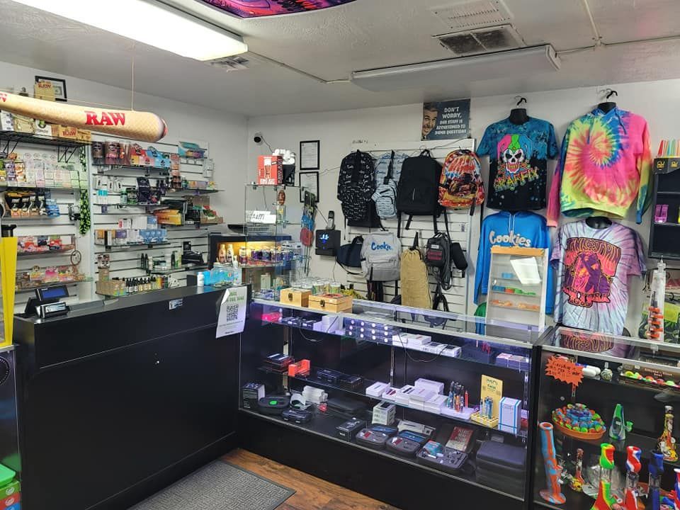 A store filled with lots of items including shirts and a baseball bat.