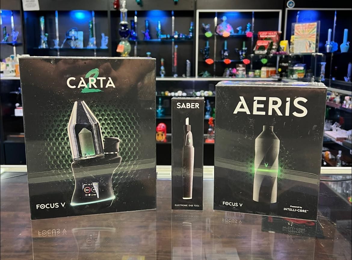 Three boxes of electronic cigarettes are sitting on a counter in a store.