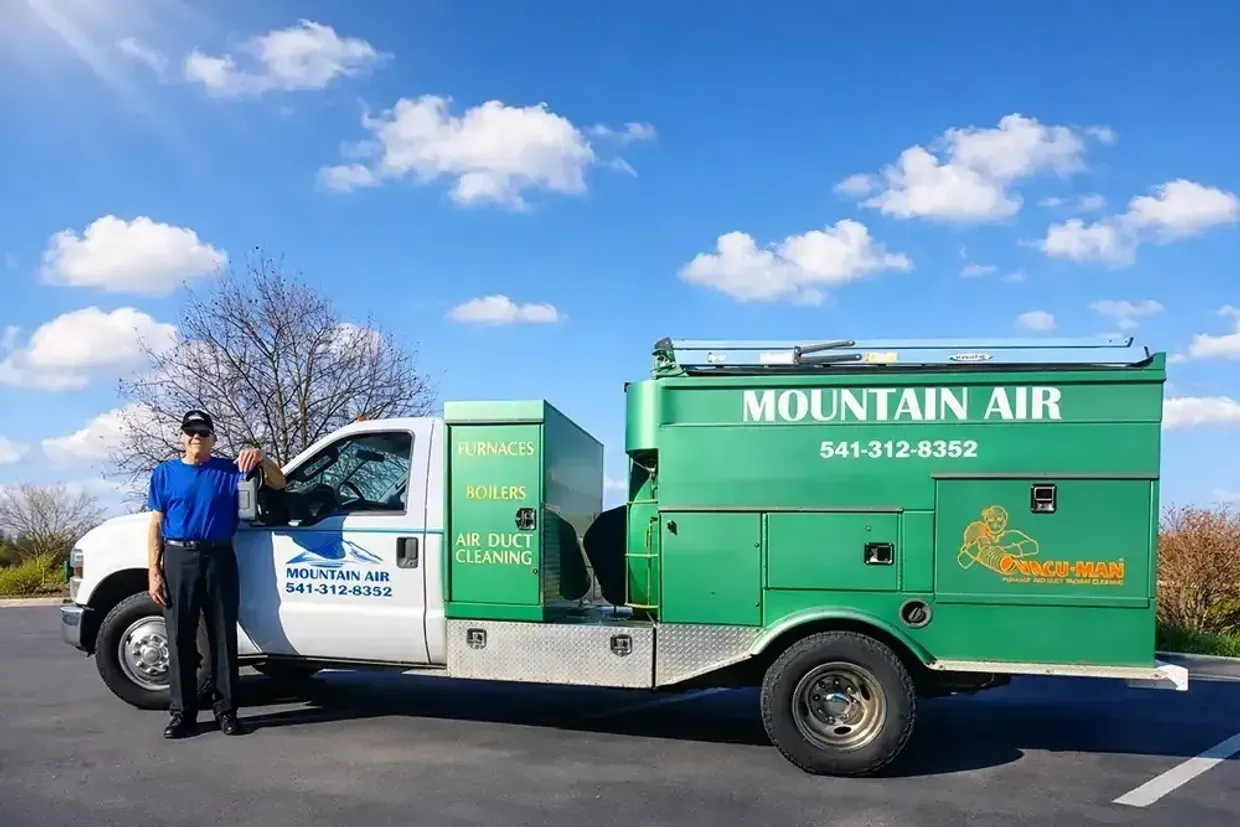 Green Mountain Air service truck parked outdoors under a blue sky with clouds