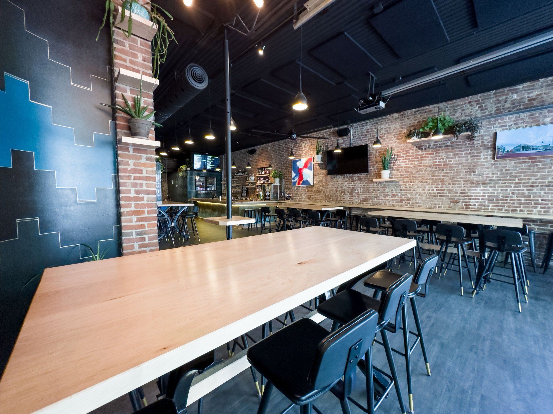 A restaurant with tables and chairs and a brick wall.