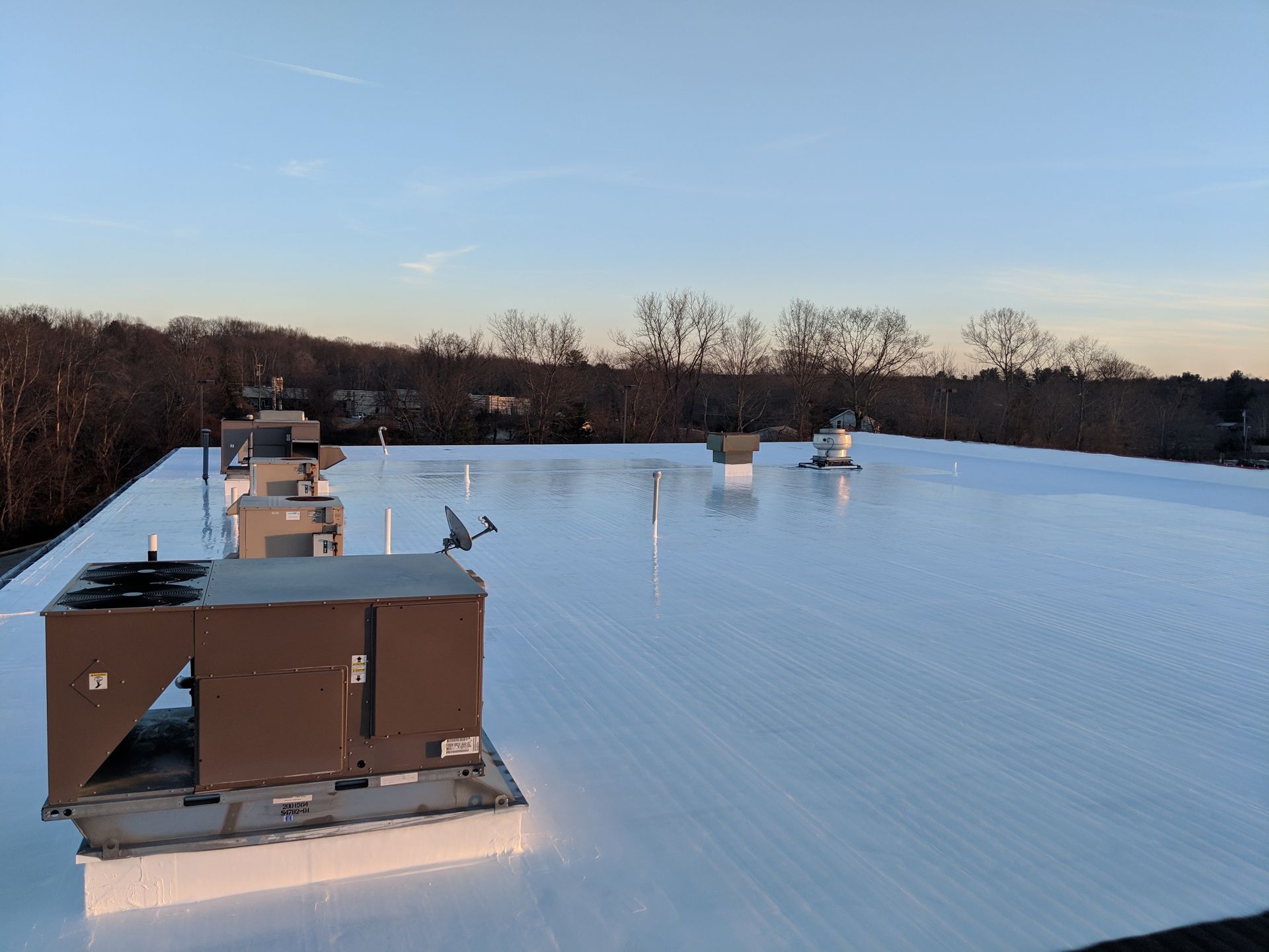 A large white roof with a lot of air conditioners on it.