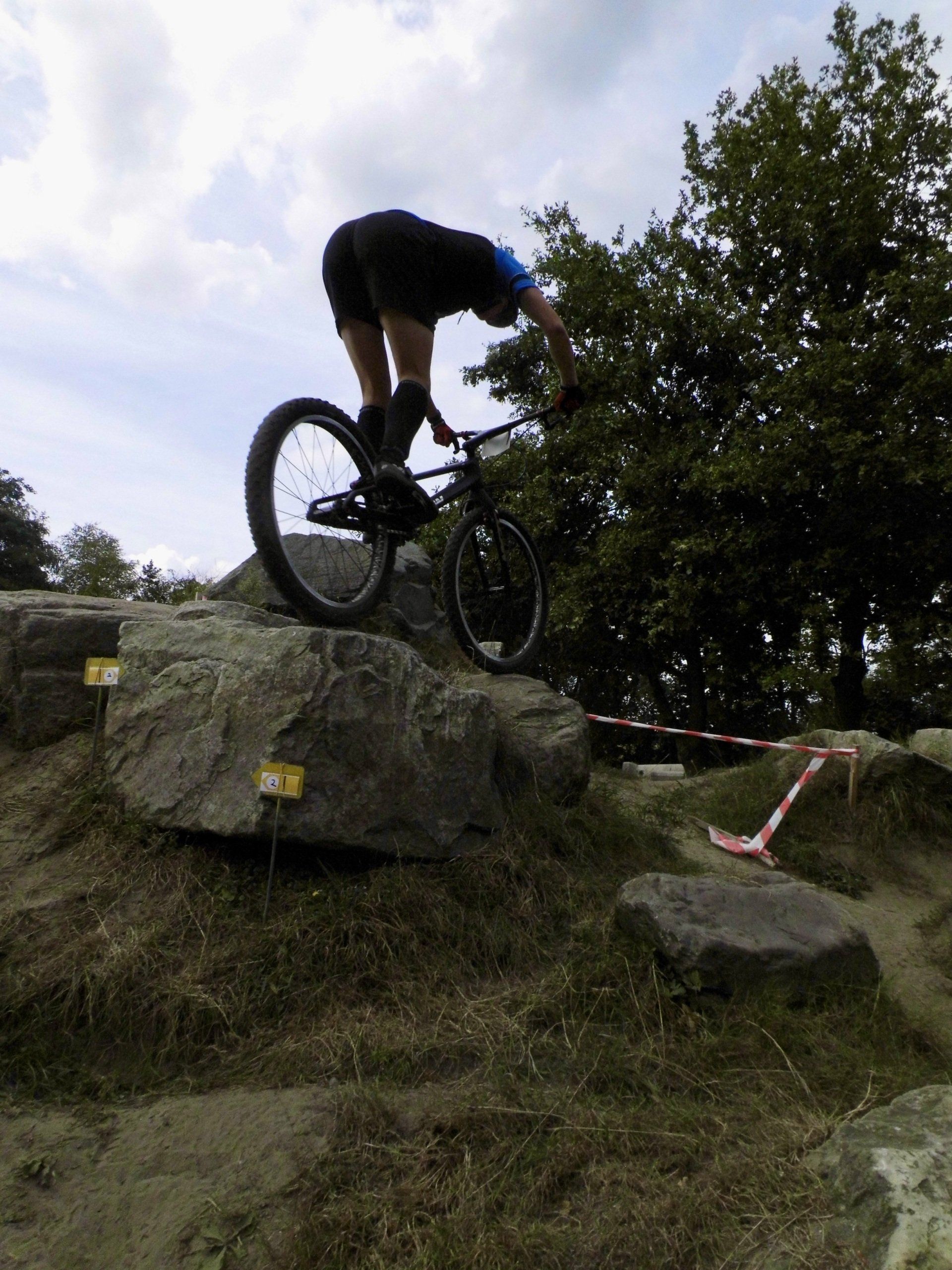 Mountainbiker balanceert op een rotsrichel op een onverhard pad in de buitenlucht.