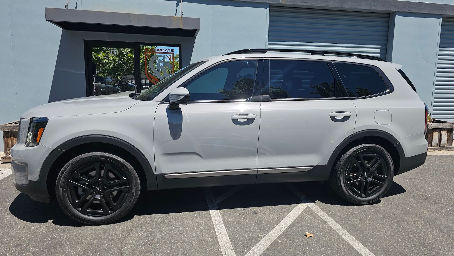 A white suv is parked in a parking lot in front of a building.