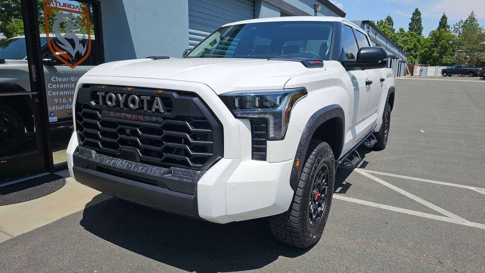 A white toyota tundra is parked in a parking lot.