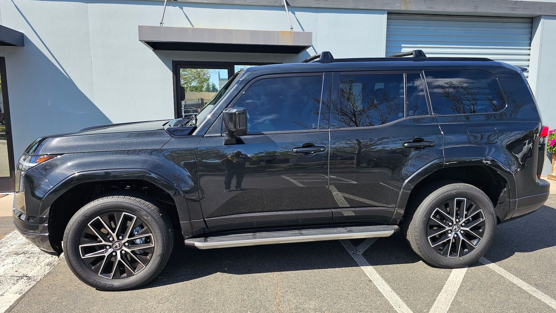 A black suv is parked in a parking lot in front of a building.