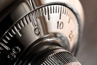 Close-up of a combination lock dial, shiny silver, with the number 10 visible.