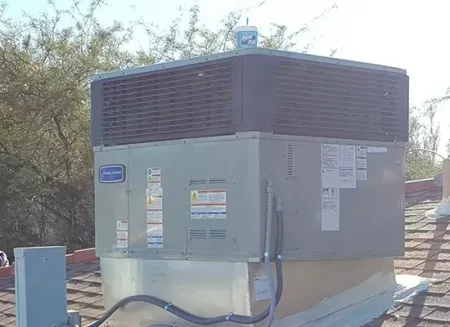 Outdoor electrical transformer unit with gray metal housing and brown vented top in a desert setting