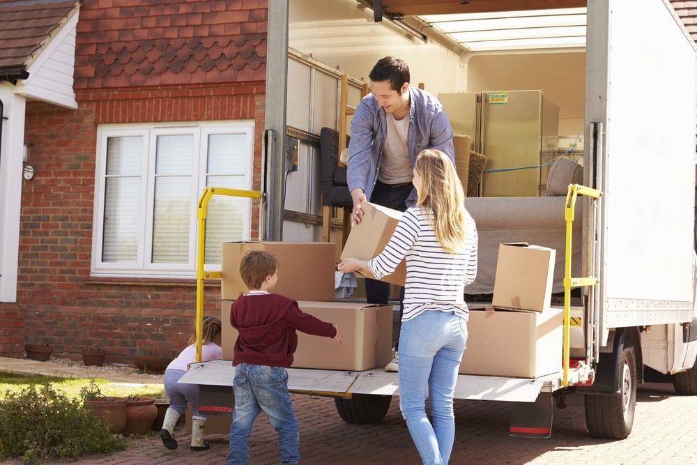 A Family Is Loading Boxes Into A Moving Truck — Greater Newcastle Removals In Lake Macquarie, NSW