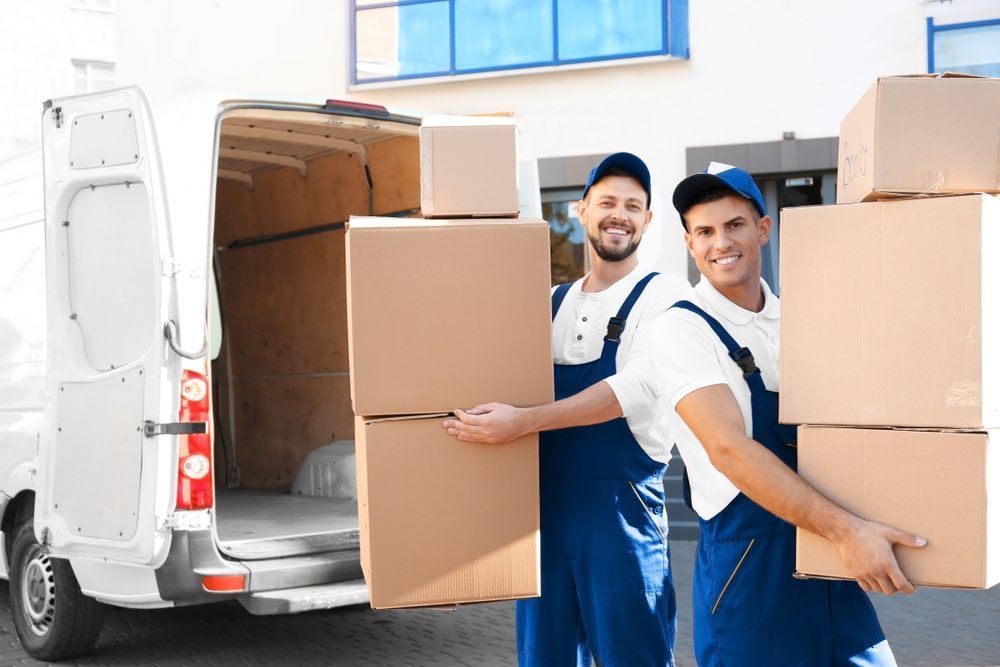 Two Men Are Carrying Boxes Out Of A Van — Greater Newcastle Removals In Rathmines, NSW