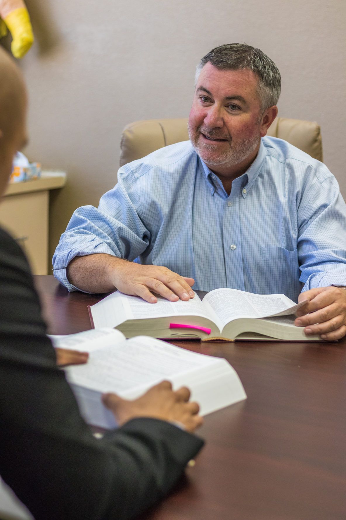 A man is sitting at a table reading a book.