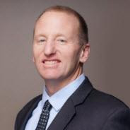 A man in a suit and tie is smiling for the camera.