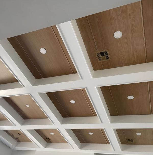 Wooden coffered ceiling with white beams and recessed lighting.