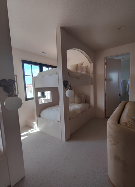 Bunk beds built into the wall of a bedroom; tan walls, white bedding, neutral tones.
