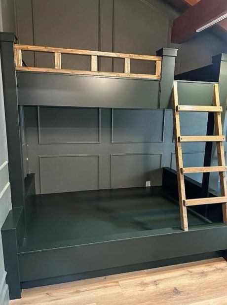 Dark green bunk bed with a light wood ladder.