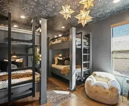 Gray bunk beds in a bedroom with star ceiling lights and a plush beanbag chair.