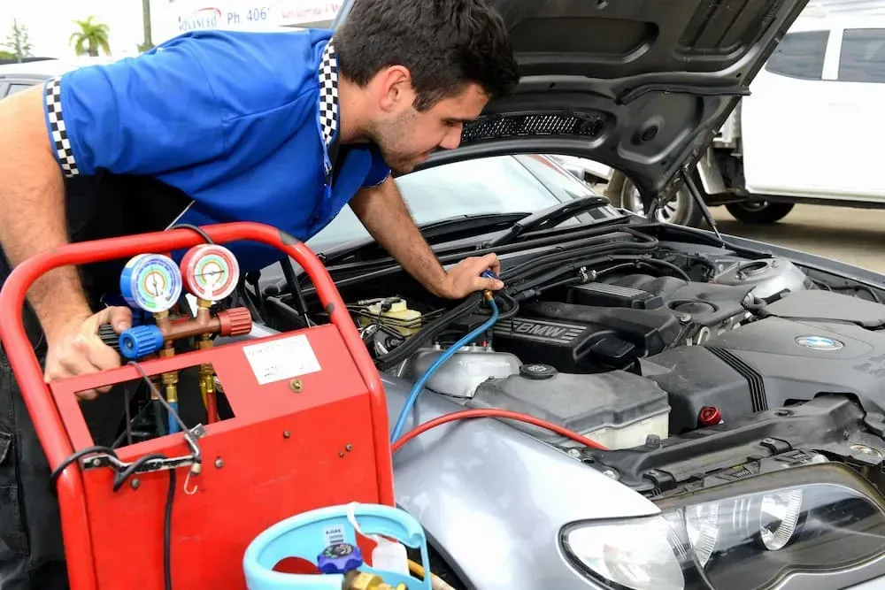 Mechanic Working on Car Engine, Using Red and Blue Gauge Machine — Advanced Auto Electrics & Mechanical in Innisfail, QLD