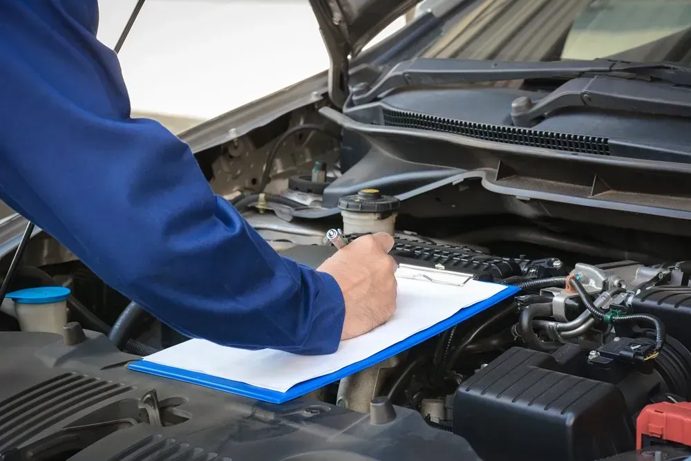 Mechanic in Blue Shirt Inspecting Car Engine — Advanced Auto Electrics & Mechanical in Innisfail, QLD