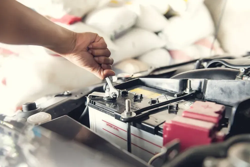 Person's Hand Using a Wrench to Work on a Car Battery — Advanced Auto Electrics & Mechanical in Innisfail, QLD