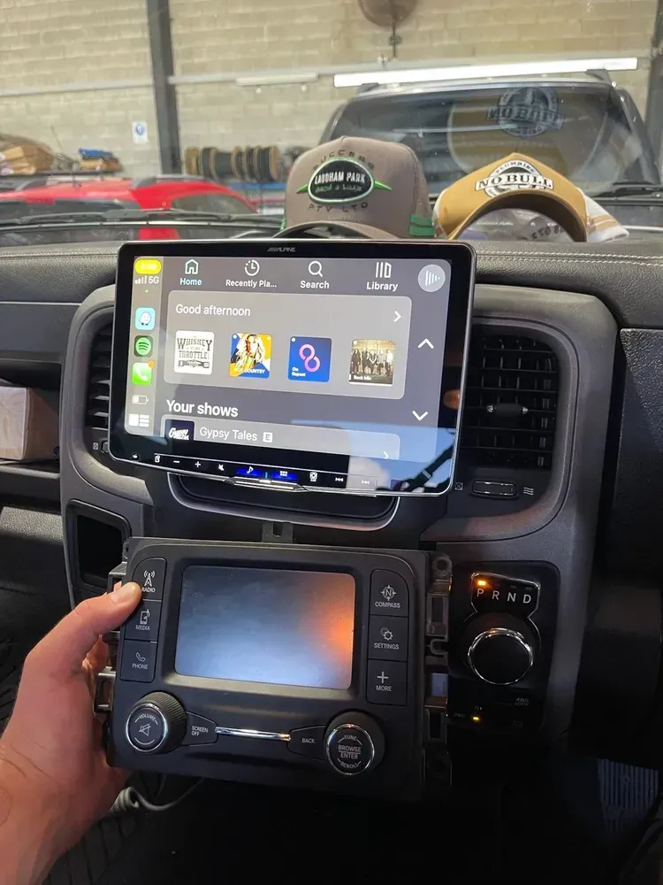 Man Holding a Car Stereo Below a Tablet-like Screen in a Vehicle — Advanced Auto Electrics & Mechanical in Innisfail, QLD
