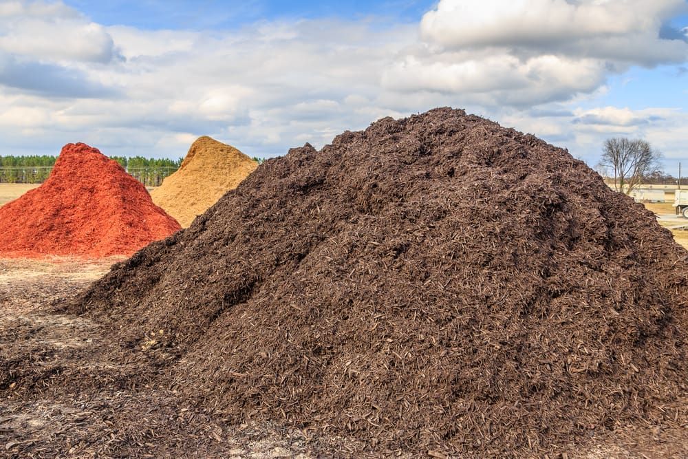 Three Piles Of Mulch Are Stacked On Top Of Each Other In A Field — Envy Landscape Supplies In Urangan, QLD