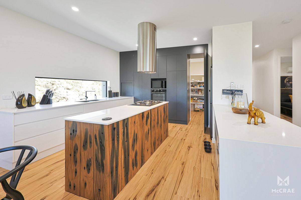 Modern Kitchen With Wooden Island and White Countertops, Black Cabinetry — Red Emperor Constructions in Cannonvale, QLD
