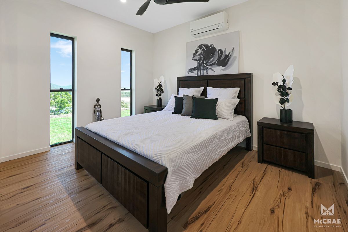 Bedroom With a Dark Wooden Bed, Nightstands, and Wooden Floors — Red Emperor Constructions in Cannonvale, QLD