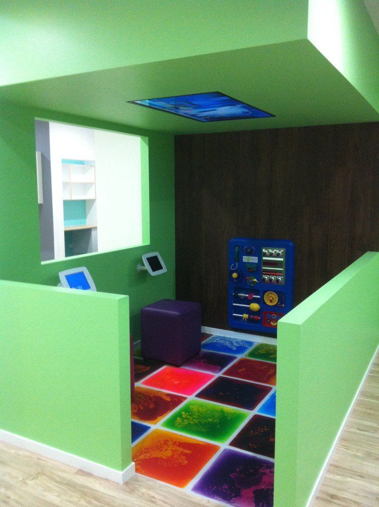 A room with green walls and a colorful floor — Red Emperor Constructions in Cannonvale, QLD