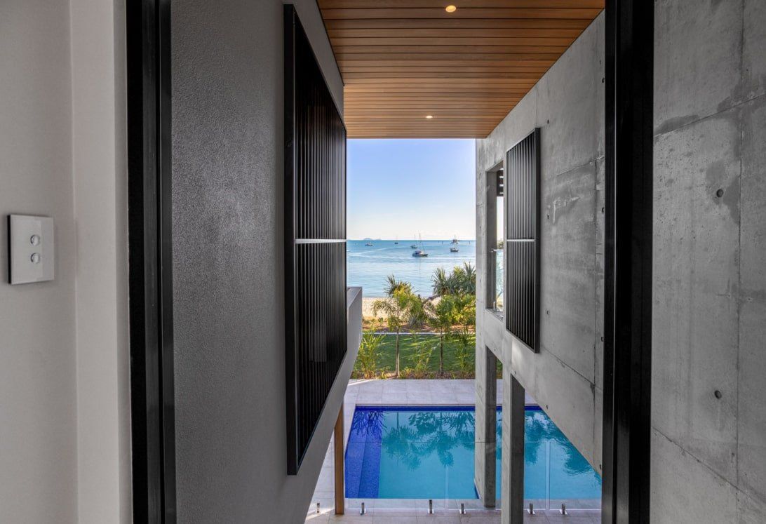 A view of a swimming pool from a hallway in a house — Red Emperor Constructions in Cannonvale, QLD