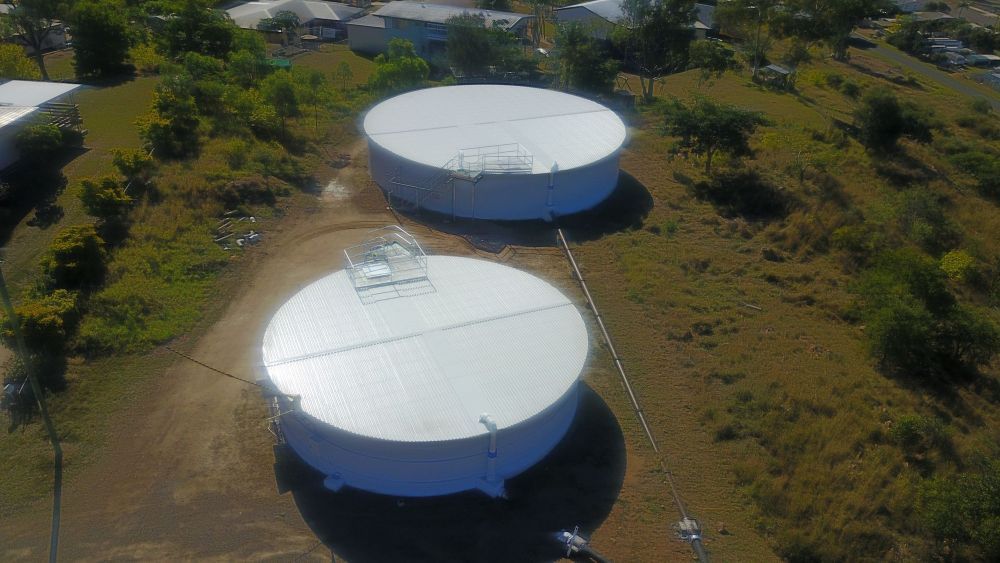 An Aerial View of Two Large White Tanks in a Field — Red Emperor Constructions in Cannonvale, QLD
