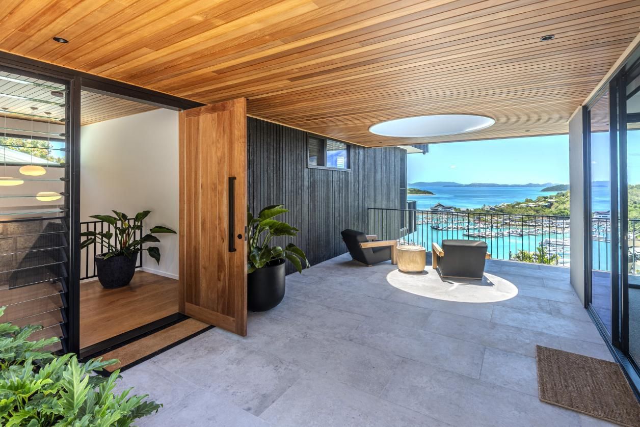 Modern Home With Wooden Door, Deck, and Ocean View — Red Emperor Constructions in Cannonvale, QLD