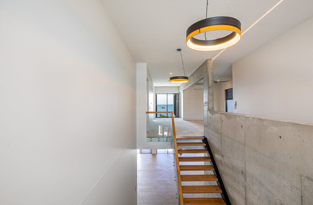 A wooden staircase leading up to the second floor of a house — Red Emperor Constructions in Cannonvale, QLD
