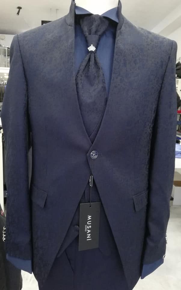 Completo a tre pezzi blu navy appeso a una gruccia, mostrato frontalmente con gilet e pantaloni abbinati.