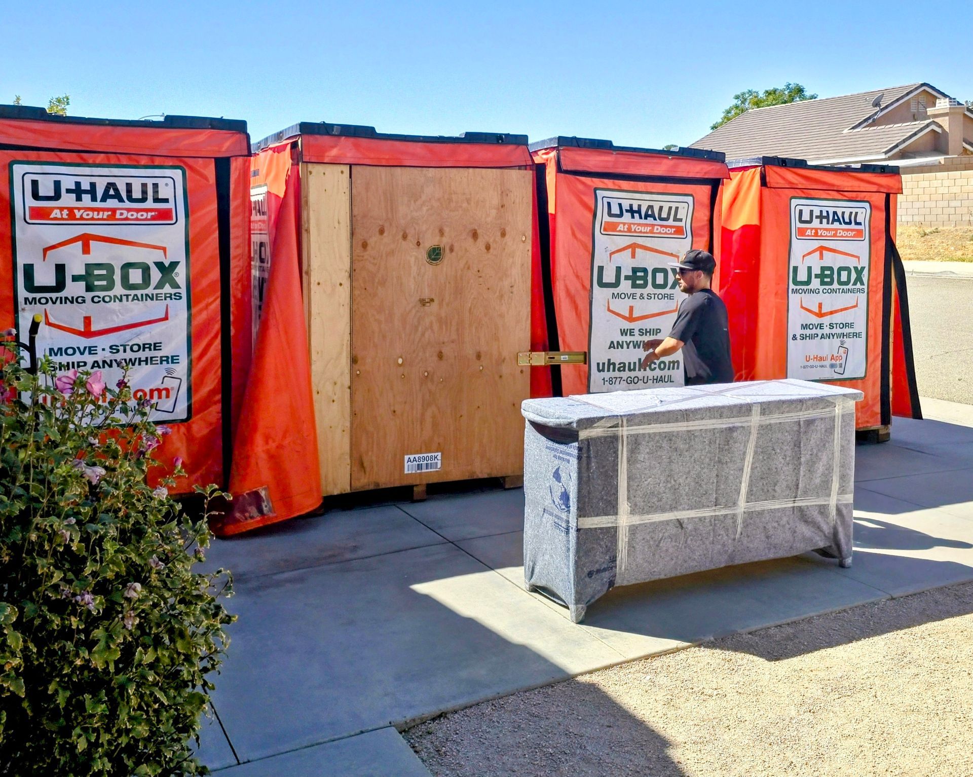 A man is standing in front of a row of u-haul boxes